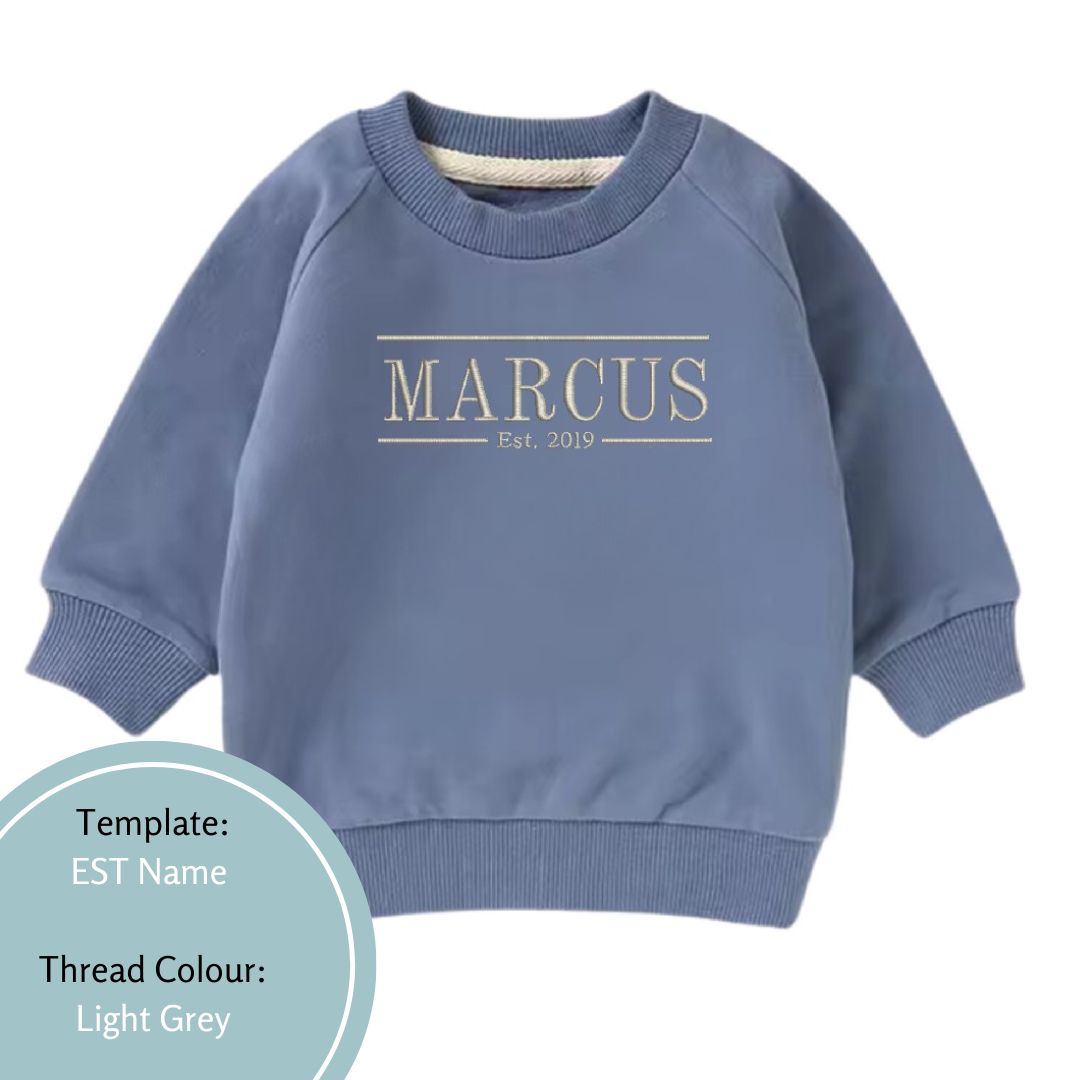 blue baby and toddler crewneck jumper embroidered with name and est date using a light grey thread colour