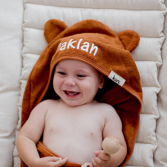 child wearing tan brown hooded bath towel newborn gift personalise with baby name embroidery
