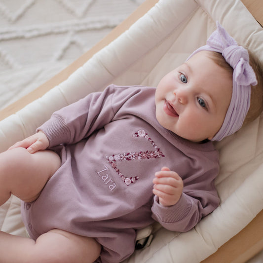 Purple Romper personalised with embroidery. A floral letter and childs name underneath