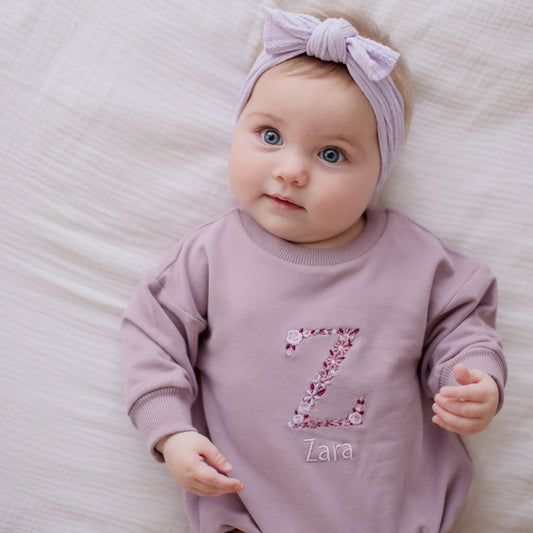 Purple Romper personalised with embroidery. A floral letter and childs name underneath