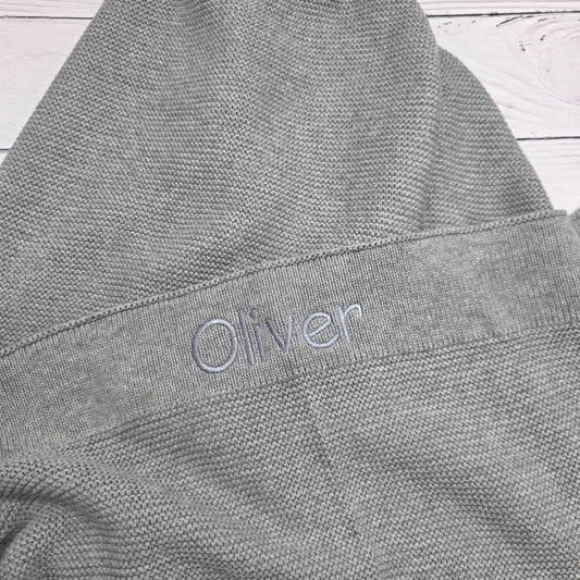 Gray fabric with 'Oliver' branding on a wooden surface