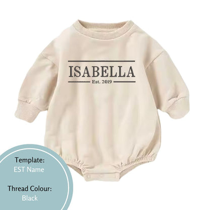 beige bubble romper embroidered with est name in a black thread