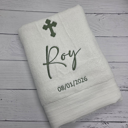 Gray towel with embroidered text and design on a wooden surface