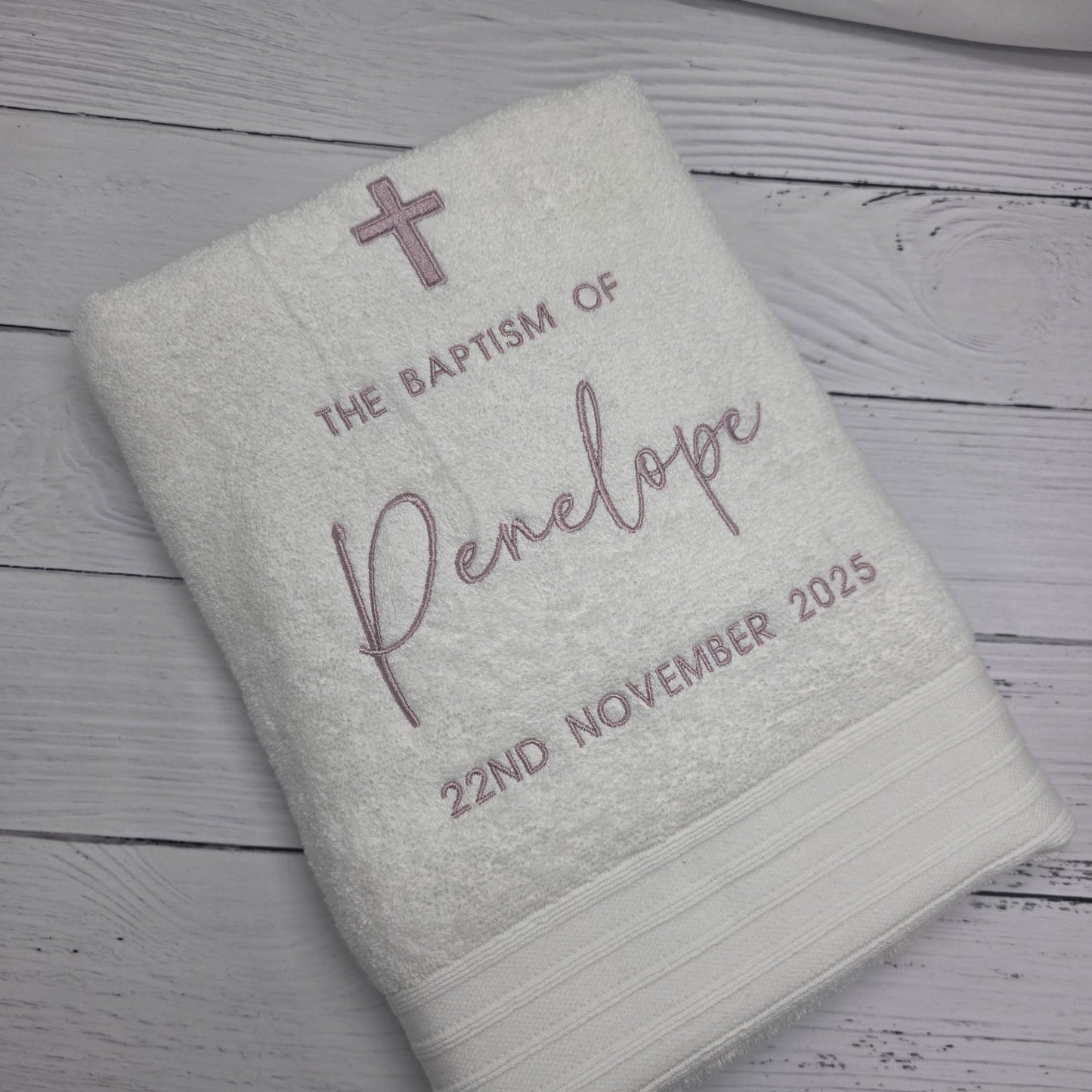 Embroidered towel with personalized text on a wooden surface