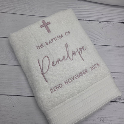 Embroidered towel with personalized text on a wooden surface