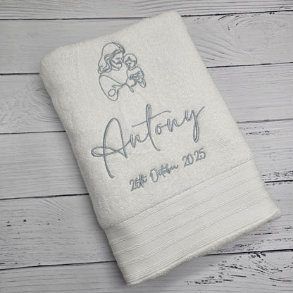 White towel with personalized embroidery on a wooden surface