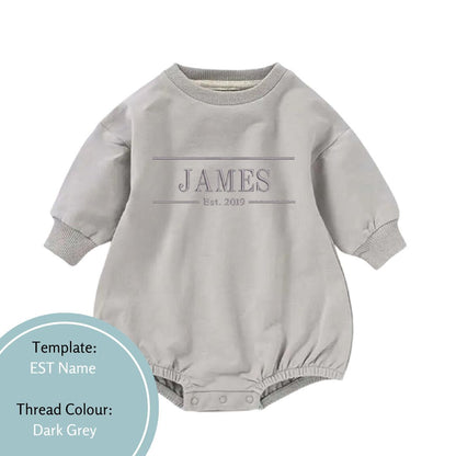 grey bubble romper with an est name and date deisgn embroidered in a dark grey thread