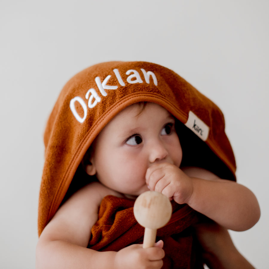 child wearing tan brown hooded bath towel newborn gift personalise with baby name embroidery