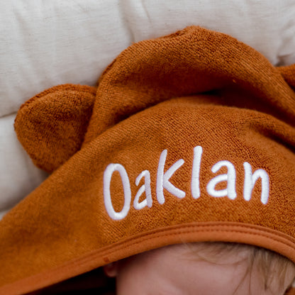 child wearing tan brown hooded bath towel newborn gift personalise with baby name embroidery