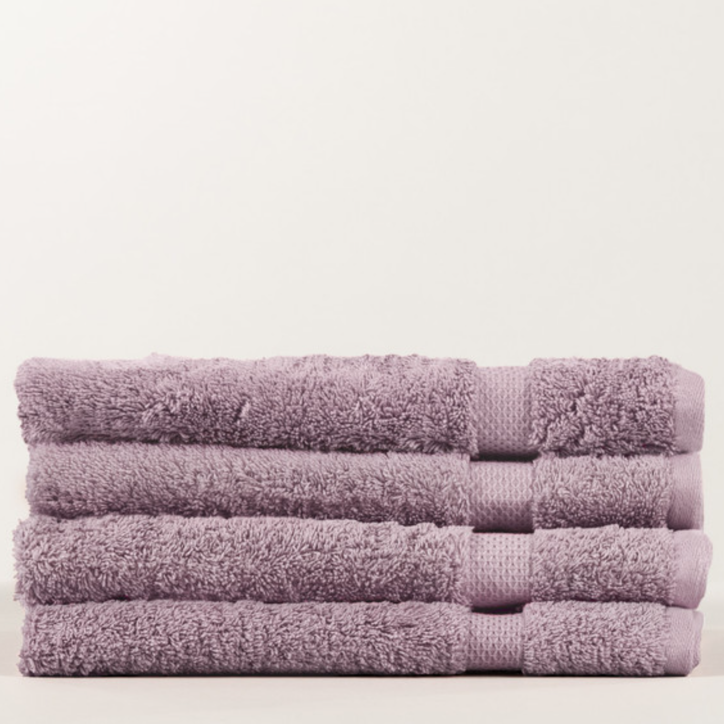 Stack of purple towels on a light beige background