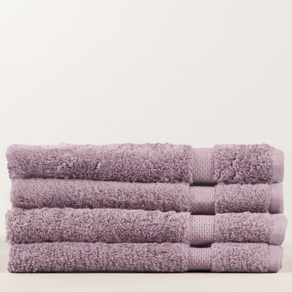 Stack of purple towels on a light beige background