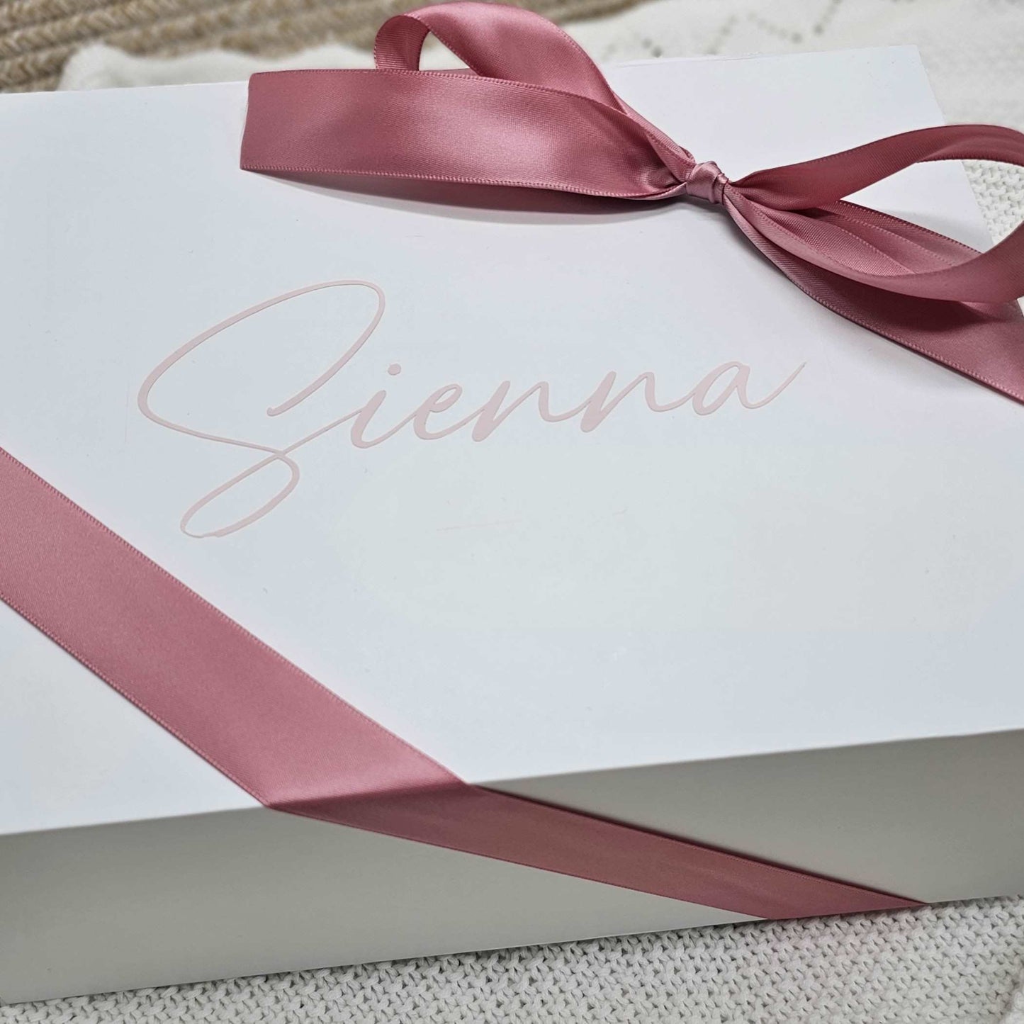 Personalized white gift box with a pink ribbon and the name 'Sienna' printed on the lid.