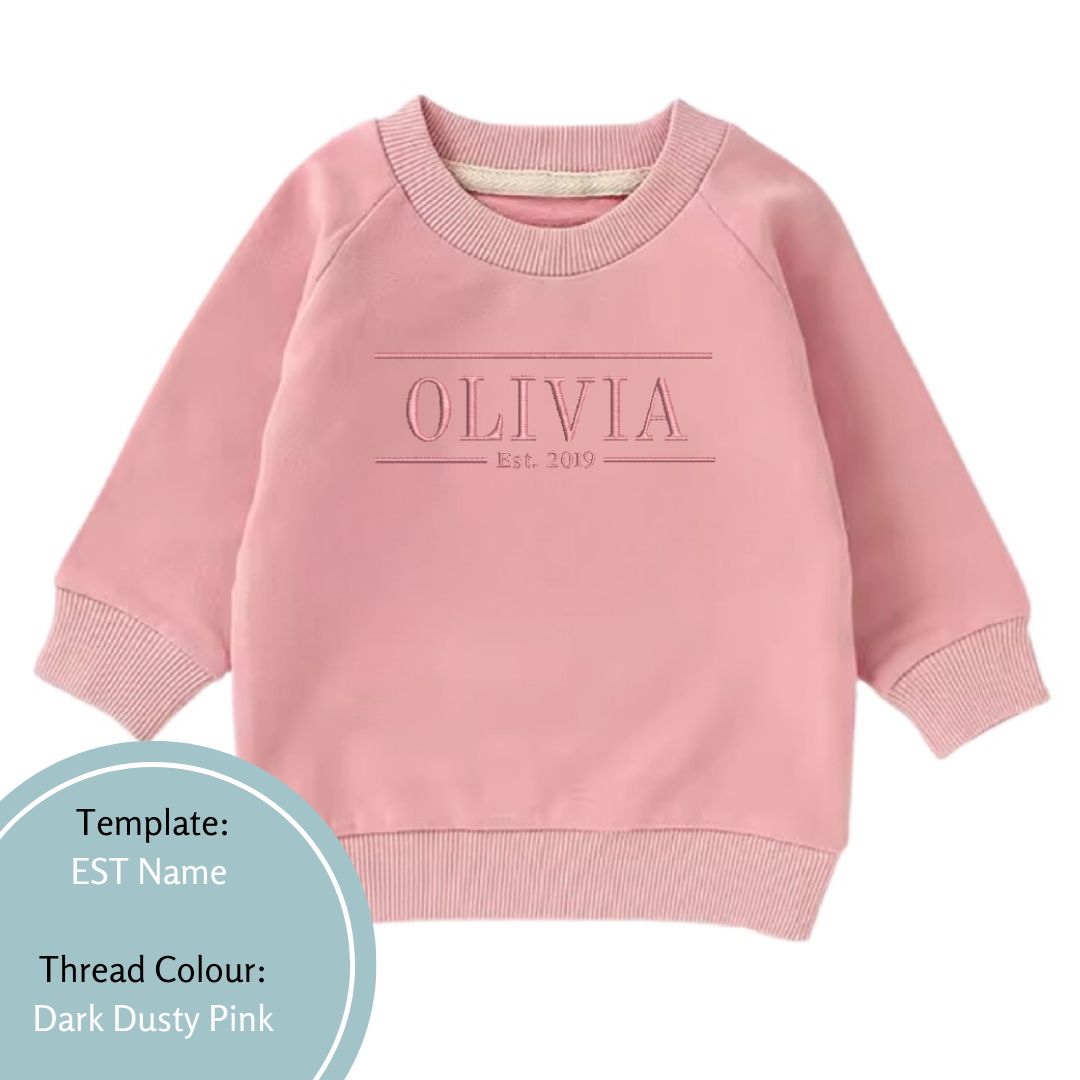 pink baby and toddler crewneck jumper embroidered with an est date and name using a dark dusty pink thread colour