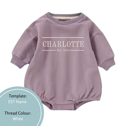 purple bubble romper with est name embroidered in a white thread