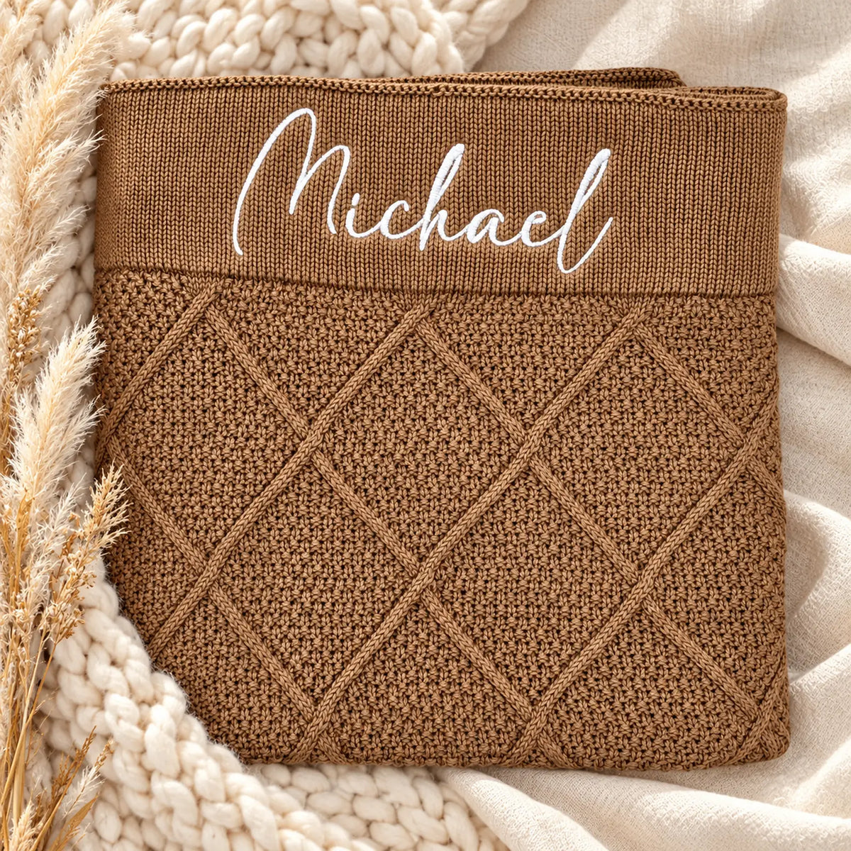 A tan brown diamond knit blankets embroidered with the name Michael