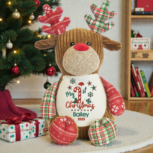 Plush reindeer toy with 'My 1st Christmas Bailey 2025' text in a festive setting.